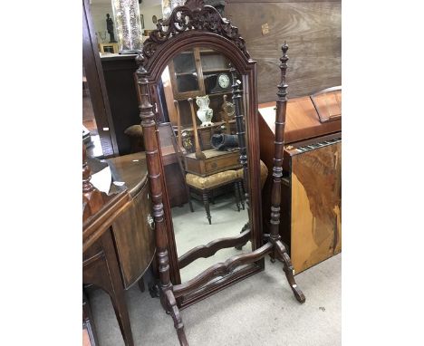 A carved mahogany Cheval mirror.