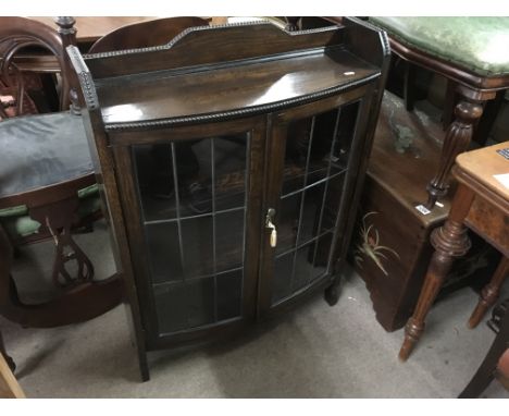 A small oak double door lead light display cabinet enclosing fitted shelves. Approximately 70cm by 90cm