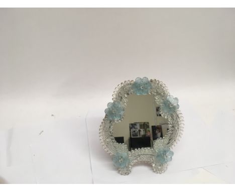 A Venetian mirror on a stand, decorated with blue flowers.