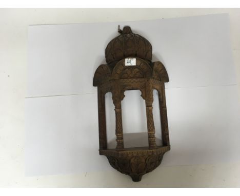 Two wooden wall decorations, one being an Indian carved wall hanging in a folate form together with a similar frame carved wa
