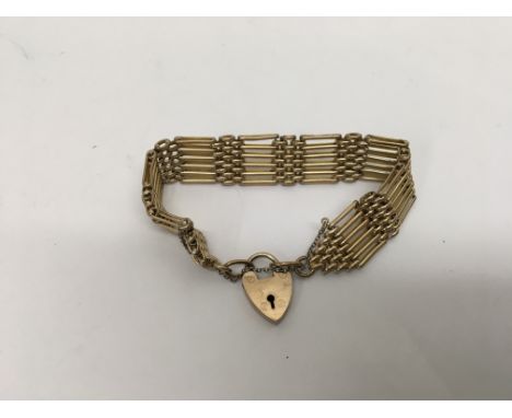 A gold tone gate bracelet.