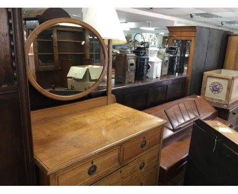 An oak dressing chest, with an oval mirror above two short and five long drawers. Approximately 82cm by 112cm (not including 