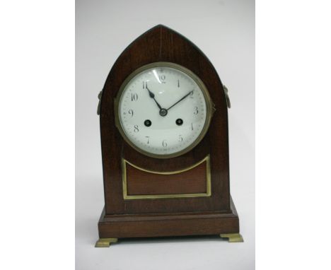 An Edwardian mahogany arched mantel clock with brass inlaid with an enonal dial with roman numerals