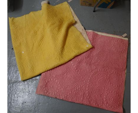 Two cotton vintage Welsh quilts with sewn in spiral and other designs; one is mustard colour with printed Paisley pattern rev