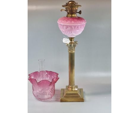 Early 20th century double oil burner lamp having cranberry glass shade above a pink opaline glass moulded foliate reservoir s