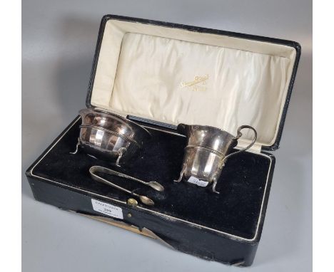 Early 20th century cased silver set comprising: helmet shaped cream jug, sucrier and matching sugar tongs, by Atkin Bros. Ltd