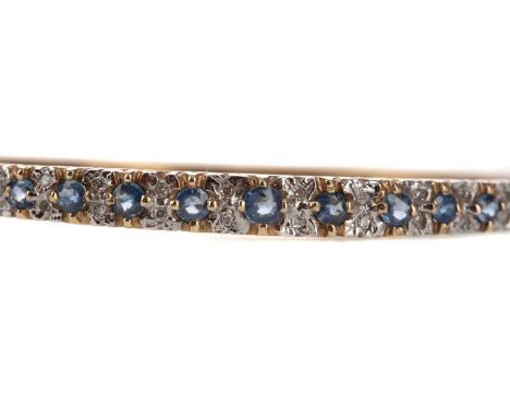 BLUE GEM SET AND DIAMOND BANGLE,set with round blue gems interspaced by pairs of diamond chips, in nine carat gold, 12.6g