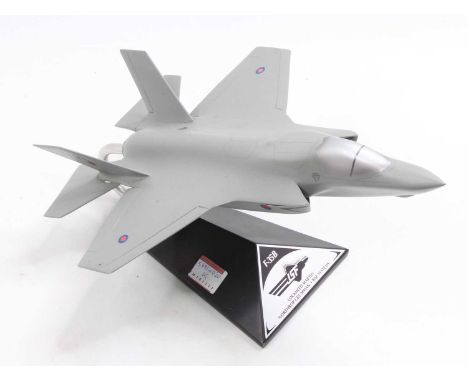 A wooden and resin scale model of a F-35B Lockheed Martin by JSF positioned on the original display stand 