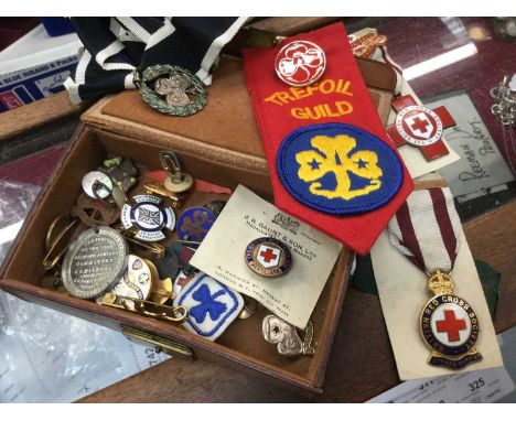 Box of Girl Guides and Red Cross badges, including silver and enamel