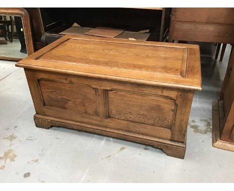 Oak coffer with panelled top and sides on bracket feet.