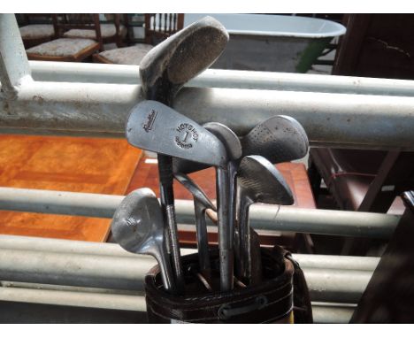 A selection of vintage golf clubs inc Kingpin, in a vintage bag