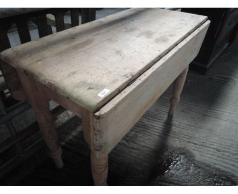 A vintage pine drop leaf table having drawer base