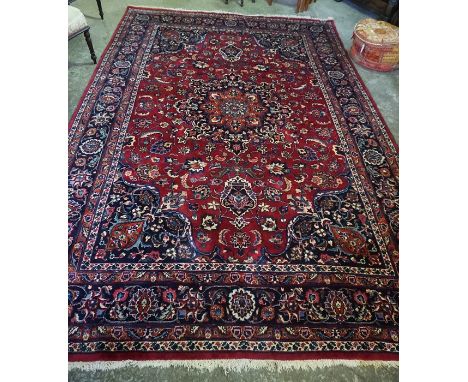 A Large Persian Carpet, Decorated with multiple floral medallions and motifs on a red ground, 344cm x 244cm 