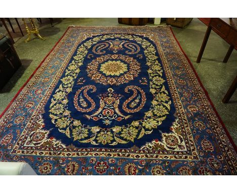 A Large Persian Carpet, Decorated with floral medallions and motifs on a blue ground, 375cm x 256cm