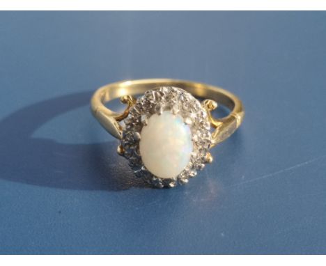 An opal &amp; diamond oval cluster ring in 18ct gold - London marks.  Finger size O.