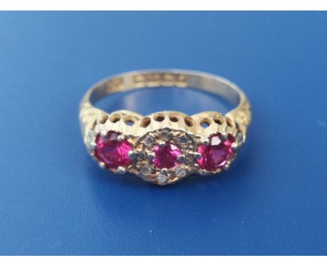 An Edwardian ruby &amp; diamond set 18ct gold ring, set with three circular rubies and a central cluster of small rose cut di