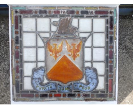 A pair of Victorian stained leaded light window panels, each with a shield surmounted by a griffin crest and having pale blue