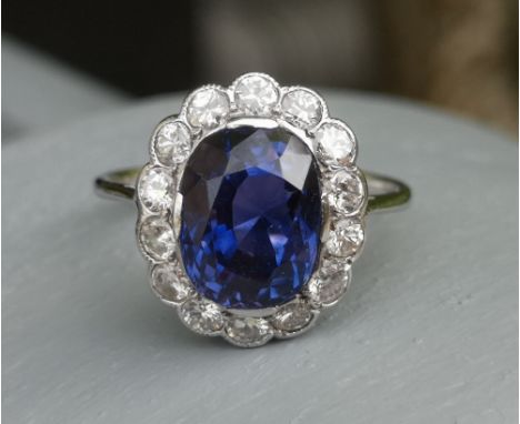 A certified natural 5.19 carat colour change sapphire &amp; diamond oval cluster ring in white metal, accompanied by a Gem &a