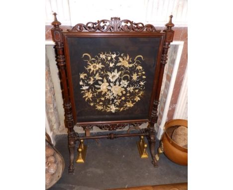 A Victorian mahogany firescreen having finley carved openwork cresting over floral embroidered silk glazed panel, Height 47",