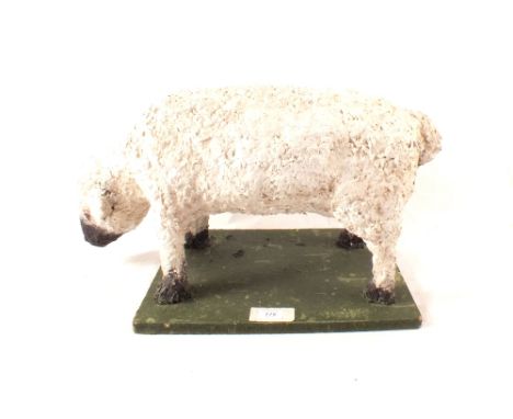 A papier mache model of a grazing lamb fixed to a later base, 24" wide
