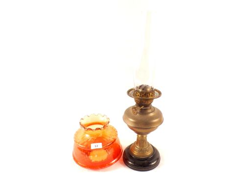 A brass column oil lamp with orange shade