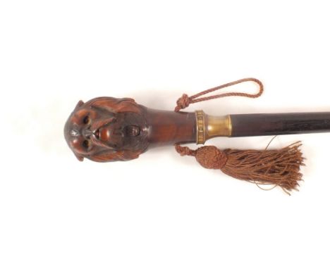 A carved wooden dogs head walking stick with mechanical protruding tongue and rolling eyes