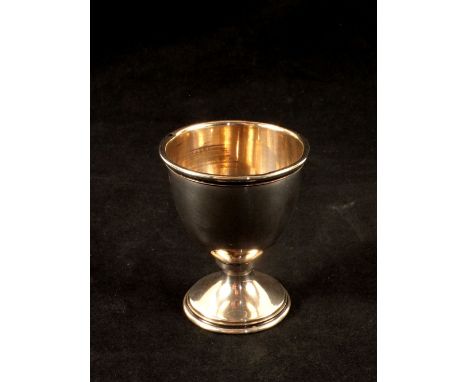 A silver egg cup plus a white metal Worcester Cathedral thimble