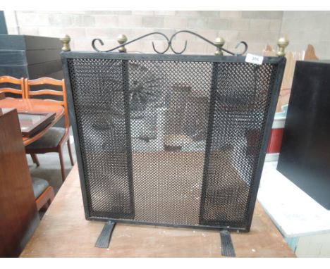 A modern black and brass fireguard