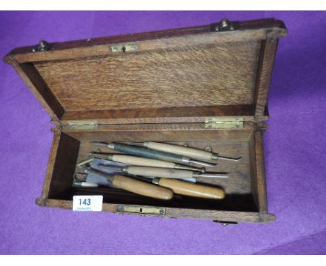 A selection of carving tools in ornate oak chest