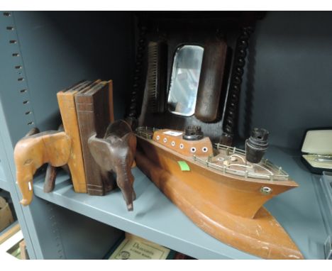 A selection of vintage wooden decorations including elephant bookends and ship lamp