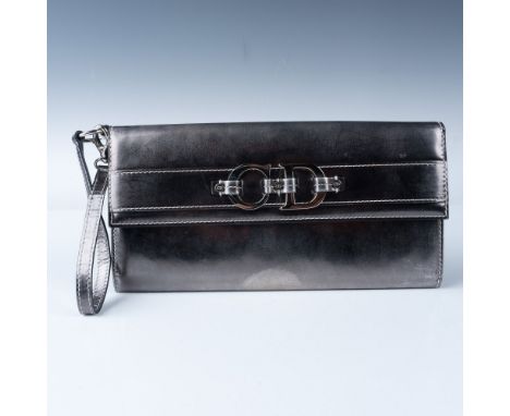 Christian Dior metallic wristlet clutch featuring a polished silver-tone "CD" logo buckle detail on the front flap. The inter