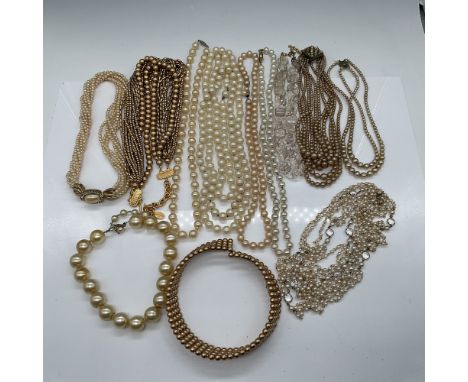 A collection of 12 faux pearl necklaces showcasing a variety of vintage-inspired designs. This assortment includes single and