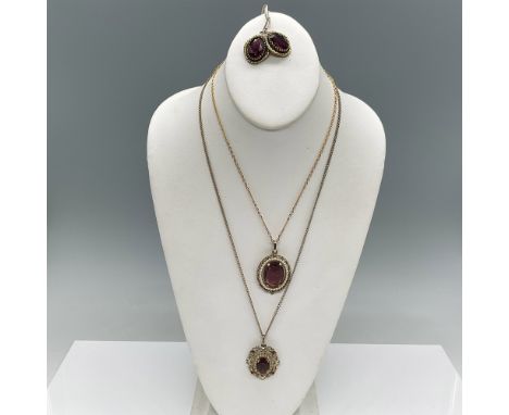 A stunning vintage jewelry set featuring intricate gold-tone designs and vibrant purple stone accents. The set includes two n