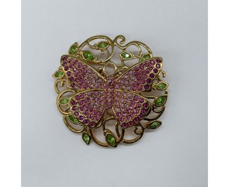 This stunning gold-toned rhodium piece features green crystal leaves and a butterfly adorned with pink crystals, gracefully s