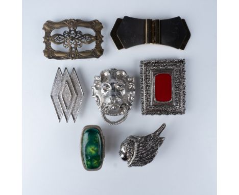 A stylish collection of seven vintage scarf clips and belt buckles, featuring a mix of designs and materials, perfect for add