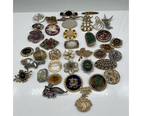 A curated collection of 41 vintage costume brooches featuring a variety of designs, materials, and motifs. This diverse assor