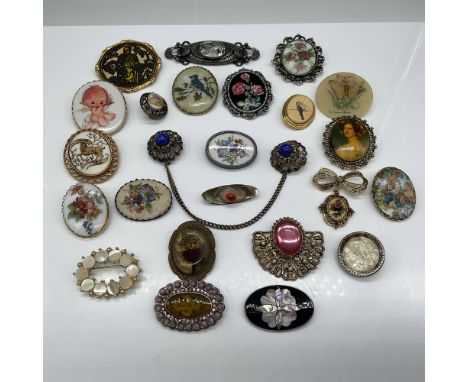 A curated collection of vintage costume jewelry brooches, featuring 24 pieces of diverse styles and materials. This lot inclu