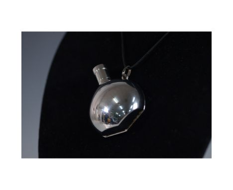This elegant Hermes pendant necklace features a perfume bottle design from the "Parfum des Merveilles" collection. The bottle