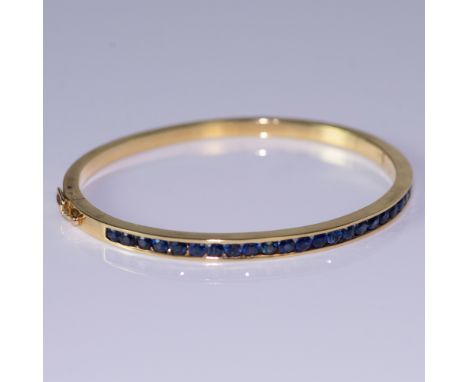Stunning bangle bracelet in 18K gold with 1.50ct blue sapphires. Measures 2.25" x 2" inside when closed. Weight 20.44 grams. 