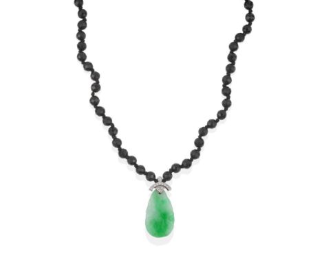 A Jade and Diamond Pendant on a Bead Necklace, the jade drop carved with a fish hangs on an 18 carat white gold diamond set m