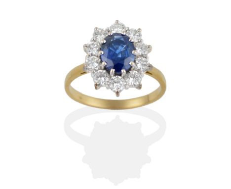 An 18 Carat Gold Sapphire and Diamond Cluster Ring, the oval mixed cut sapphire within a border of round brilliant cut diamon