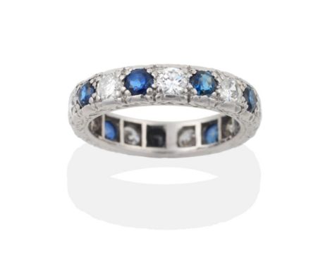 A Sapphire and Diamond Eternity Ring, nine round brilliant cut diamonds alternate with round cut sapphires in crimped claw se