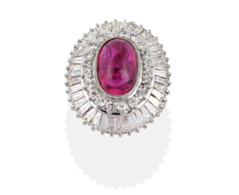 A Ruby and Diamond Cluster Ring, an oval cabochon ruby in a rubbed over setting, within a two-tier border of round brilliant 