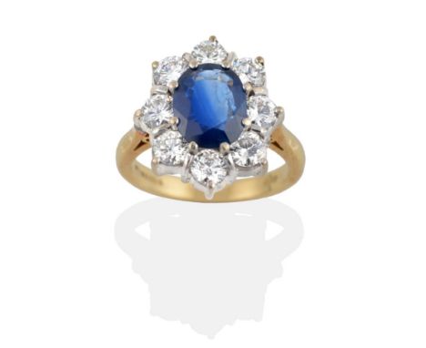 An 18 Carat Gold Sapphire and Diamond Cluster Ring, the oval mixed cut sapphire within a border of round brilliant cut diamon