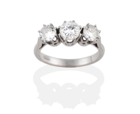 A Diamond Three Stone Ring, the round brilliant cut diamonds in white claw settings to a pointed shoulder plain polished shan