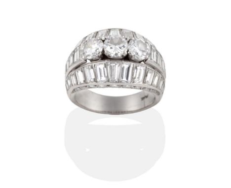 ^ A Diamond Ring, three round brilliant cut diamonds in claw settings, to a tapering shank of tapered baguette cut diamonds w