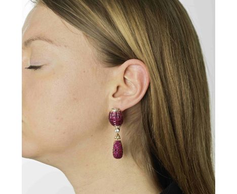 PAIRE DE BOUCLES D'OREILLES RUBIS ET DIAMANTSEn forme de tonneau et goutte, invisiblement sertis de rubis calibrés, accentués