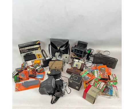 Cameras and vintage film to include Canon AE-1, Polaroid portrait, and various other cameras, filters, film and accessories.