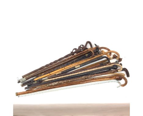 Comprehensive collection of walking canes, various styles and ages, four with silver tops. Including a vintage Nailsea glass 