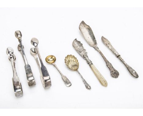 Three pairs of Georgian and later sugar tongs, together with three butter knives, a tea caddy style spoon and a mustard spoon